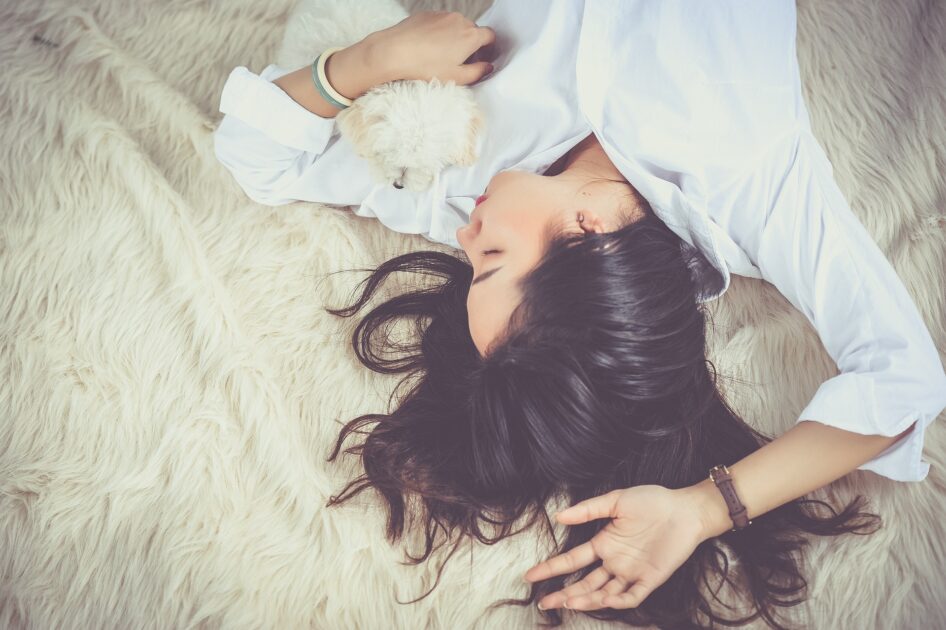 犬と一緒に寝る女性