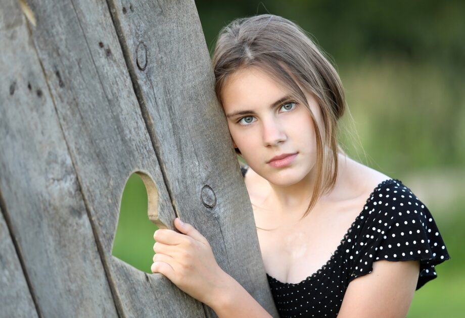 ハート型の穴に手をかける女性